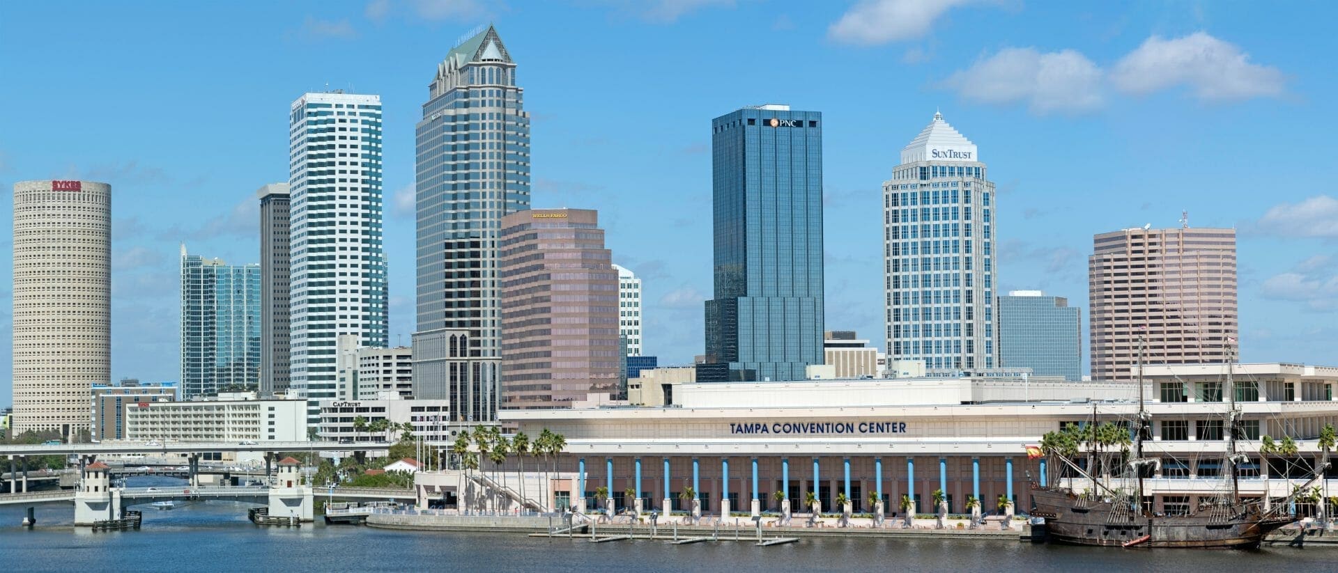 A city skyline with tall buildings and a river.