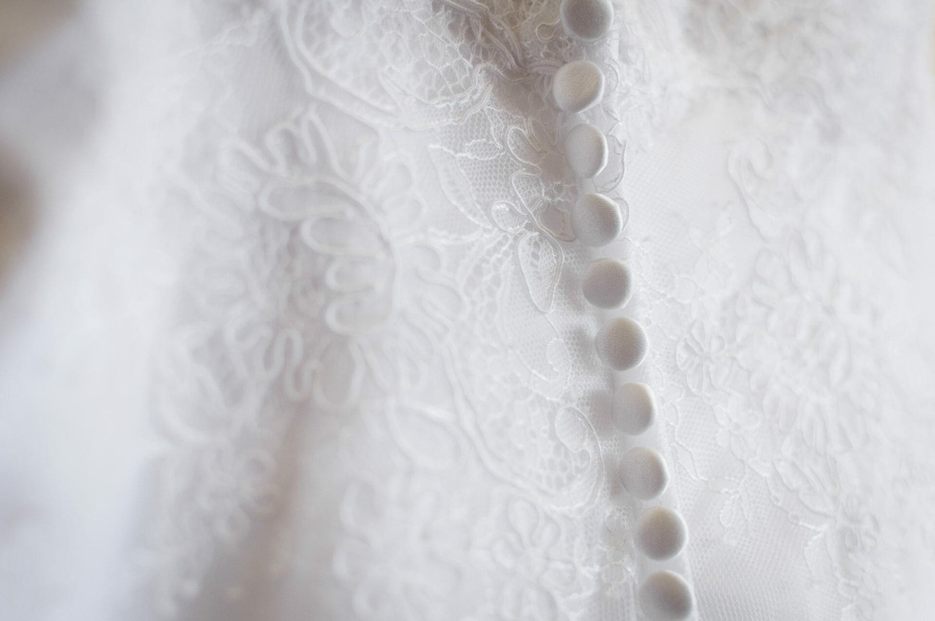 A close up of a white wedding dress.